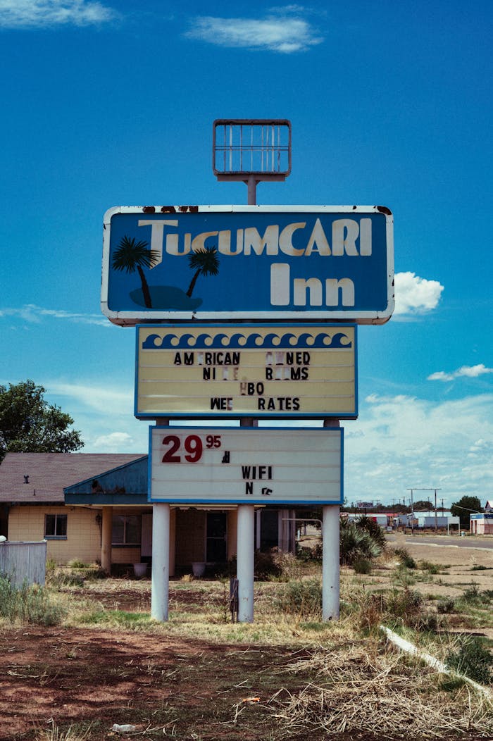 Retro motel sign for Tucumcari Inn with summer blue sky, evoking nostalgia and road trip vibes.