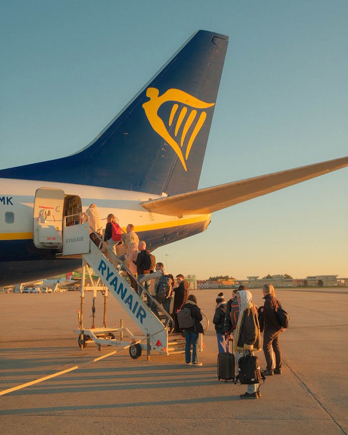 Travelers board a Ryanair plane at sunset in Porto, capturing the essence of budget travel.